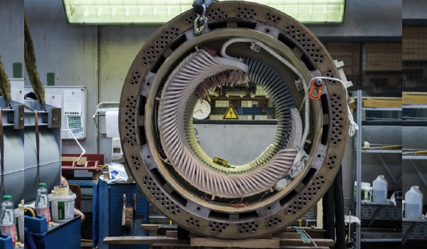 Technician performing AC/DC electric motor rewinding and inspection in industrial workshop