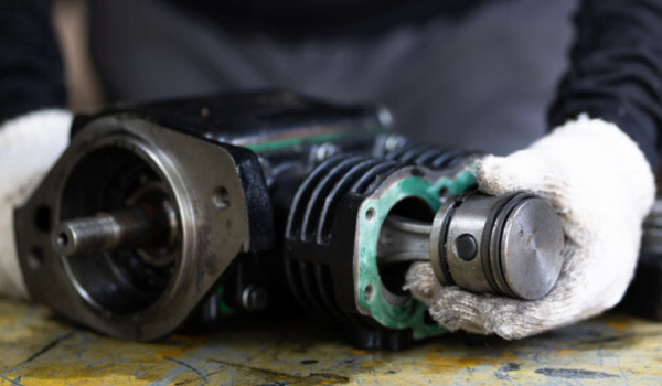 Technician performing maintenance on industrial air compressor system