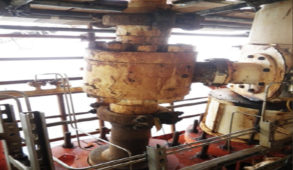 Technician inspecting annulus vent port system on offshore flexible riser infrastructure