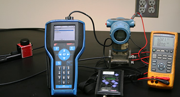 Technician calibrating industrial pressure and temperature instrumentation using traceable calibration equipment