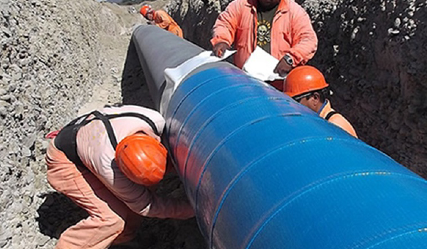 Composite wrap reinforcement being applied to corroded industrial pipeline infrastructure