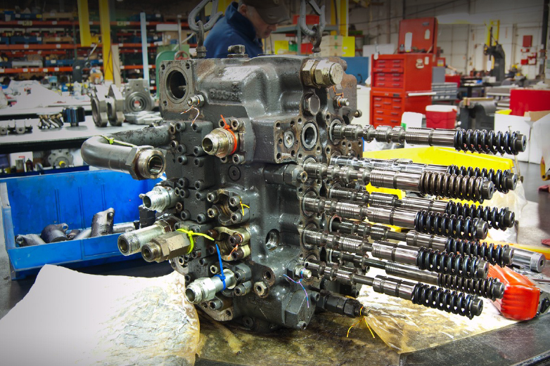 Technician performing precision disassembly and repair of a hydraulic main control valve