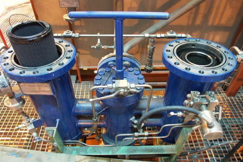 Technician performing on-site hydraulic oil filtration on running industrial equipment