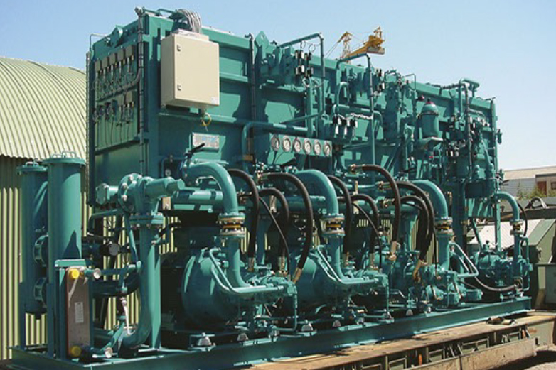 Hydraulic system installation and commissioning on industrial equipment with technicians working on piping and control units