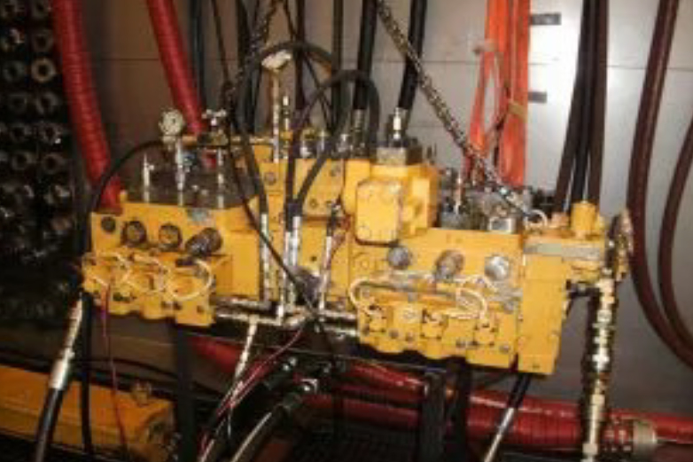 Technician performing precision repair and testing of hydraulic control valves in a workshop