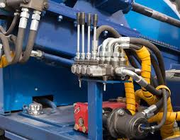 Hydraulic technicians performing diagnostics and testing on industrial hydraulic equipment in a workshop