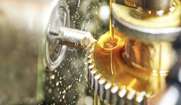 Technician performing lubrication system inspection and oil sampling in industrial plant