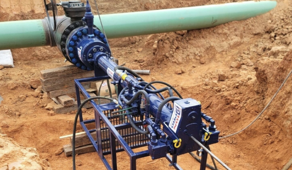 Technicians performing hot tapping and line stopping operation on pressurized pipeline system