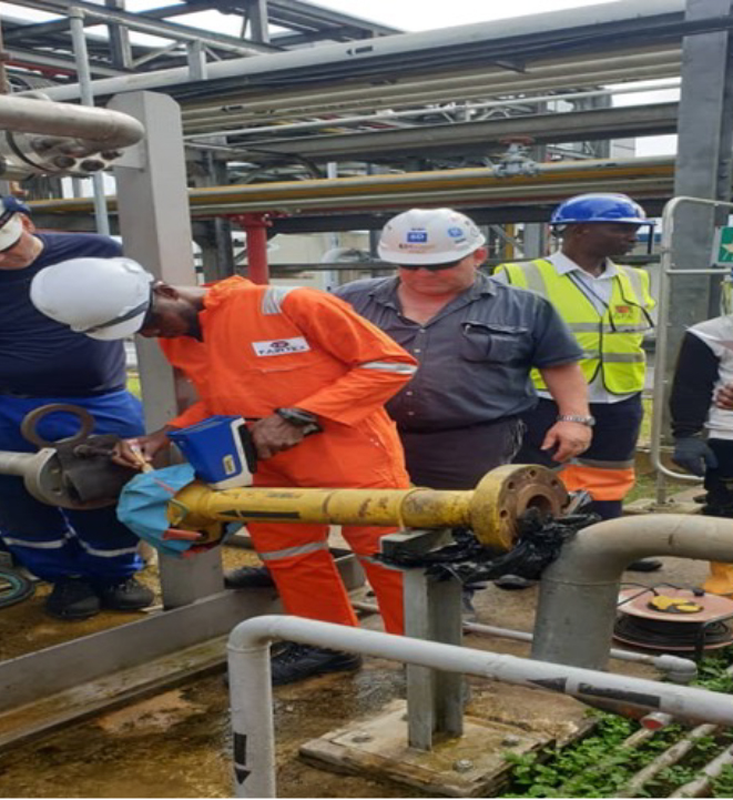 Technician performing PMI alloy verification using portable XRF analyzer on industrial piping