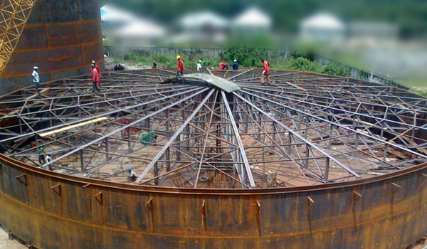 Large above-ground welded steel storage tanks under construction at an industrial facility