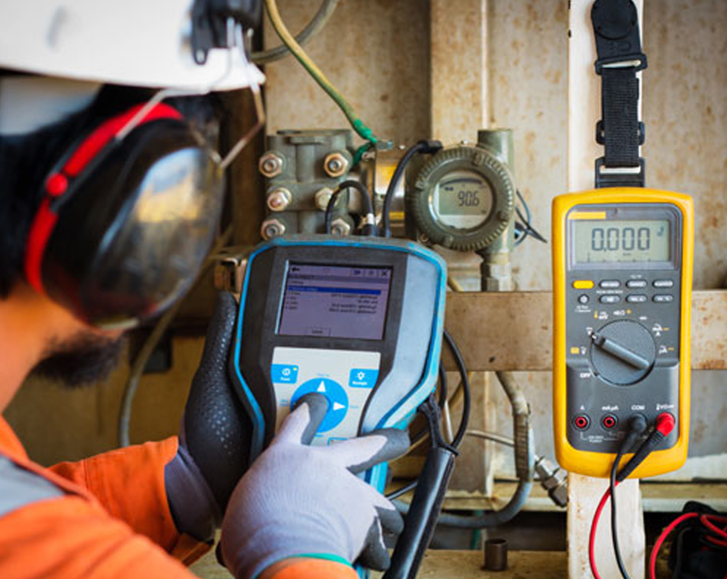 Technician performing calibration and verification of industrial process instruments in an oil and gas facility.